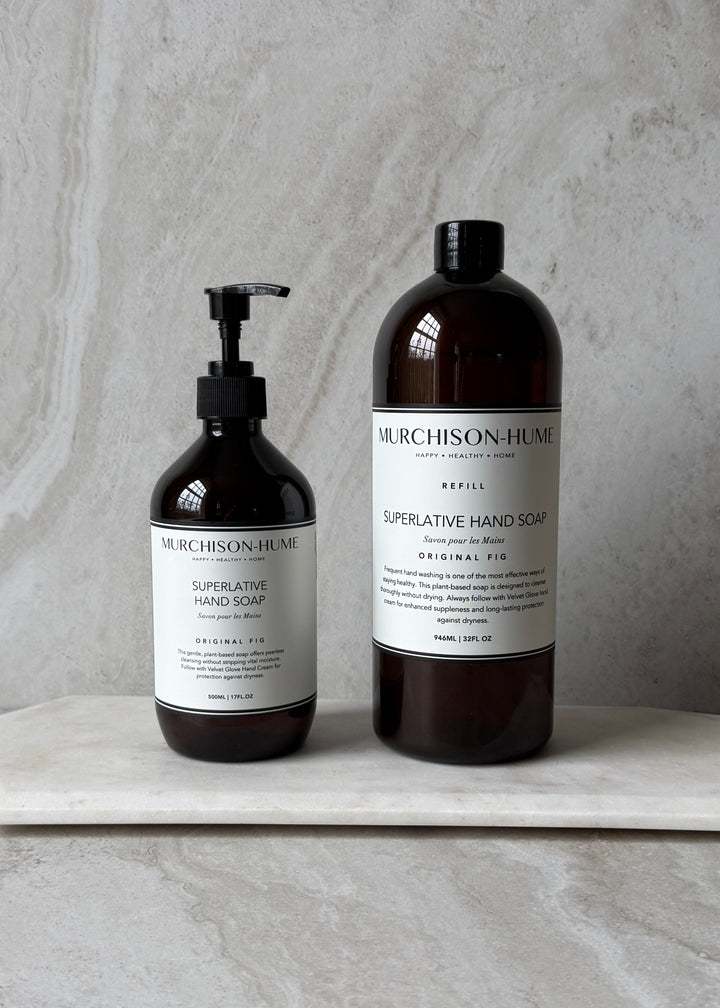 Two bottles of Murchison-Hume hand soap on a marble surface with a gray background